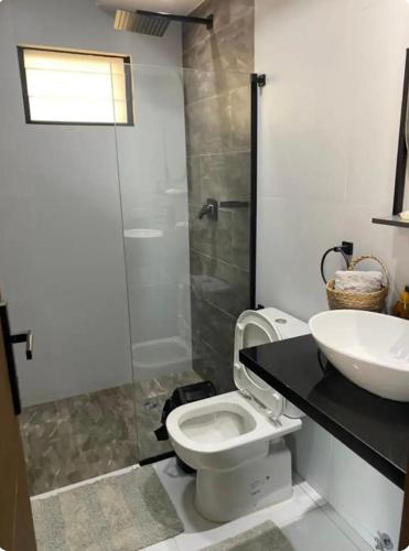 y baño con lavabo, aseo y ducha. en Monoambiente, en Trinidad