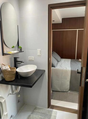 een badkamer met een wastafel, een spiegel en een bed bij Monoambiente in Trinidad