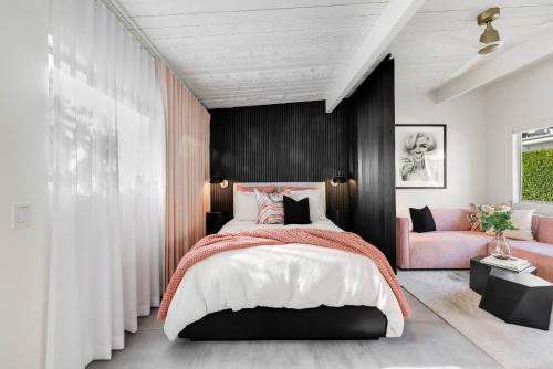 a bedroom with a large bed and a pink couch at Condo 606 W Arenas Rd Unit 2 Palm Springs in Palm Springs