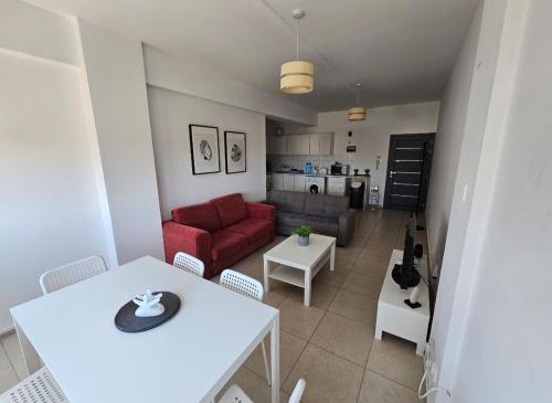 a living room with a white table and a red couch at The Heart of the City in Limassol