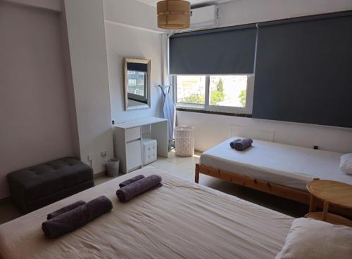 Un dormitorio con dos camas y una silla y una mesa. en The Heart of the City, en Limassol