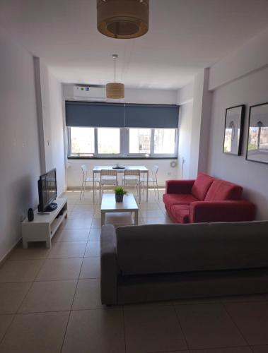 a living room with a red couch and a table at The Heart of the City in Limassol