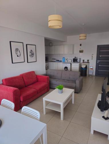 a living room with a red couch and a table at The Heart of the City in Limassol