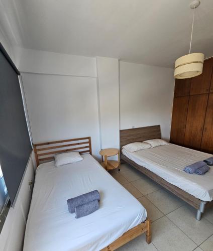 a bedroom with two beds and a lamp at The Heart of the City in Limassol
