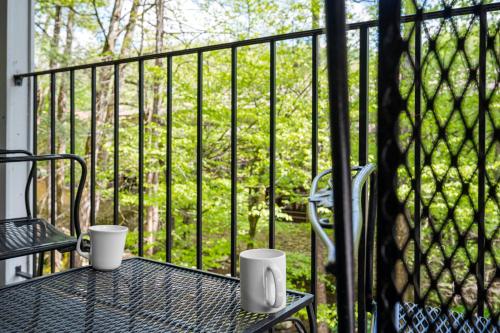 two cups sitting on a table on a balcony at Carr's Northside Hotel and Cottages in Gatlinburg