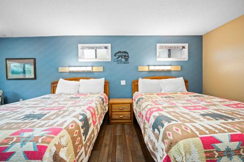 two beds sitting next to each other in a room at Carr's Northside Hotel and Cottages in Gatlinburg