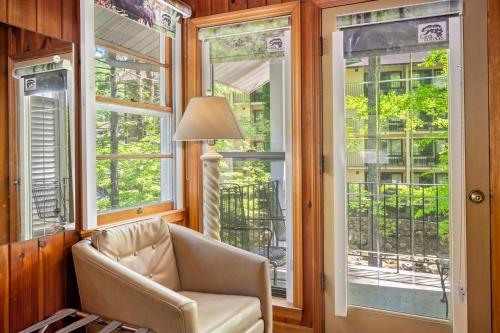 a living room with a chair and windows at Carr's Northside Hotel and Cottages in Gatlinburg