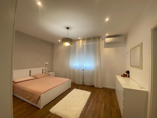 una camera con letto, finestra e tappeto di Lellolocations - Casa Osina a San Costanzo