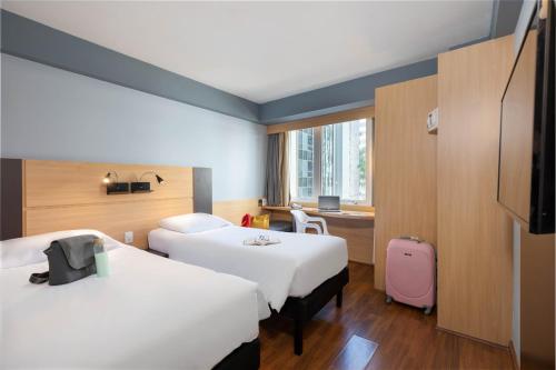 Habitación de hotel con 2 camas y ventana en ibis Sao Paulo Paulista en São Paulo