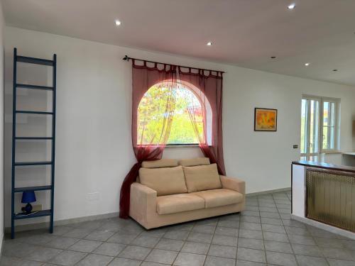 - un salon avec une chaise et une fenêtre dans l'établissement Villa Fiore, à Nettuno