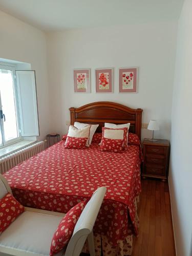 een slaapkamer met een bed met een rood dekbed bij Casa Pancha in Ribadeo