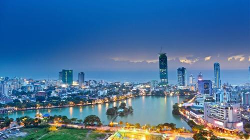 eine Skyline der Stadt in der Nacht mit einem Fluss und Gebäuden in der Unterkunft Sun Rest Colombo in Colombo