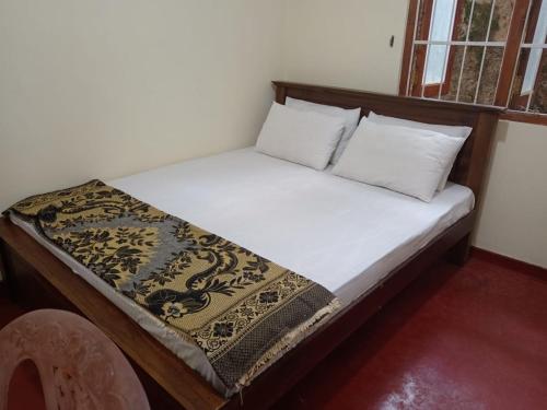 ein Bett mit zwei Kissen auf einem Zimmer in der Unterkunft Sun Rest Colombo in Colombo