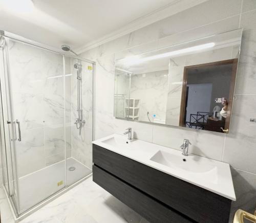ein weißes Bad mit einem Waschbecken und einer Dusche in der Unterkunft Lisbon Baixa 208 Apartment-Chiado in Lissabon