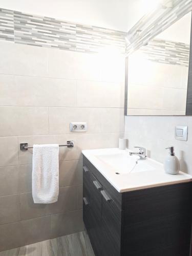 a white bathroom with a sink and a mirror at Casa Los Lajares in La Santa