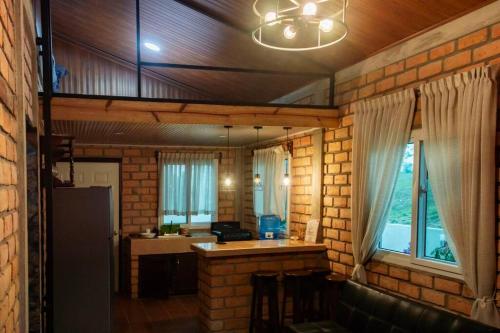 uma cozinha com uma parede de tijolos e uma cozinha com um balcão em Cabaña Campestre Privada Tinita´s Chalet em Taulabé