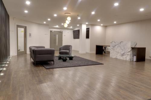 a living room with two chairs and a table at Van Gogh Apartment, Bedford - Fast Wifi, Gym & FREE Parking in Bedford