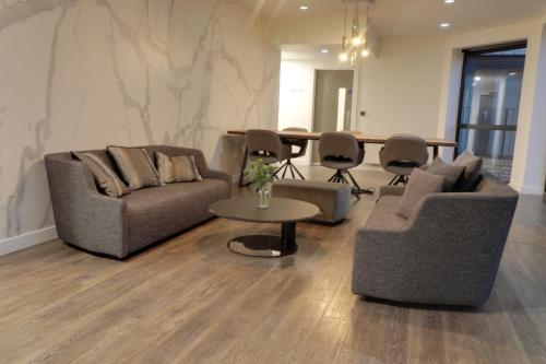 a living room with two couches and a table at Van Gogh Apartment, Bedford - Fast Wifi, Gym & FREE Parking in Bedford