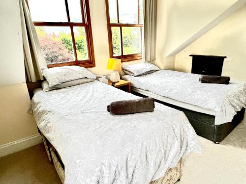duas camas num quarto com duas janelas em Anita's Home in Kidderminster em Kidderminster