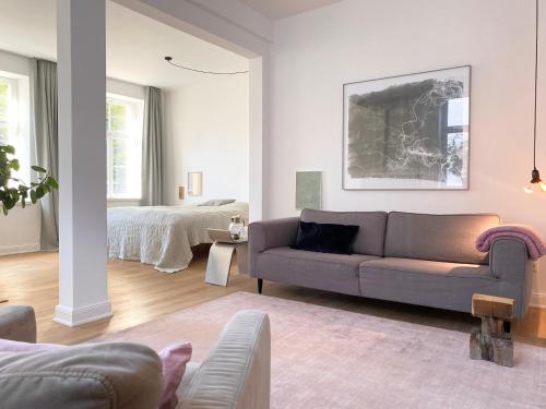 ein Wohnzimmer mit einer Couch und einem Bett in der Unterkunft Zehuus Beletage in Köln