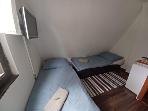 Habitación pequeña con 2 camas y TV. en Chata Ružín-Rolova Huta en Margecany