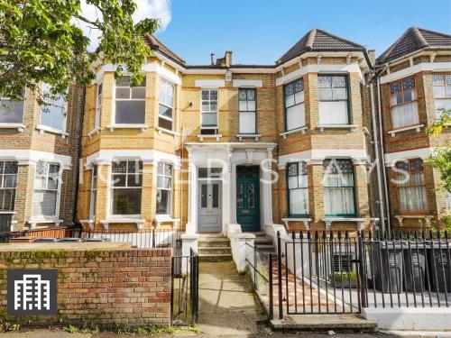 a large brick house with a green door at Hackney Guest Rooms in London