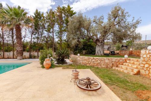 un patio con una pared de piedra y una piscina en Riviera Paradiso en Aghia Marina