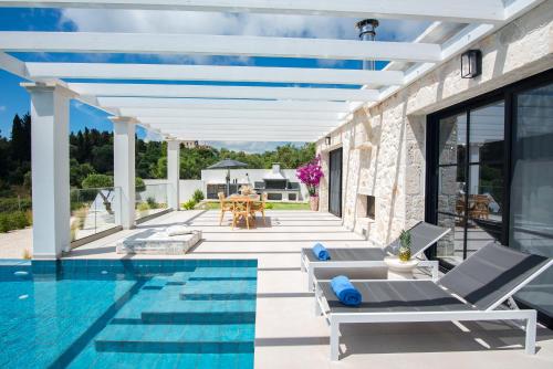 a patio with a swimming pool and a house at LUZ BLANCA in Agios Leon