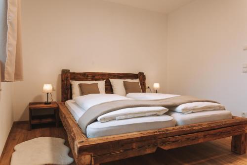 a bedroom with a wooden bed with two pillows at Matscherhof Lana in Lana