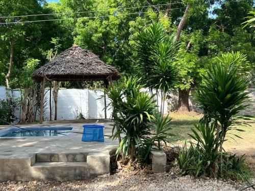 einen Pavillon mit einem blauen Mülleimer im Hof in der Unterkunft Tabasamu Gardens in Diani Beach