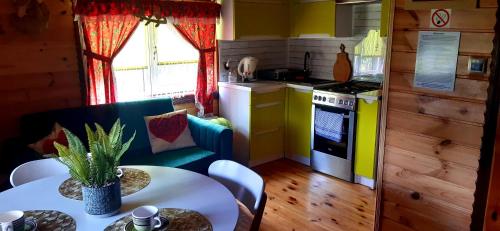 a kitchen with a table and a kitchen with yellow at Domek KRAJNO ŚWIETA KATARZYNA in Krajno Pierwsze