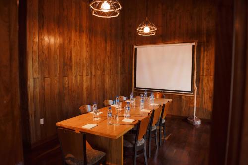 a conference room with a long table and a white screen at Chan Chich Lodge in Gallon Jug