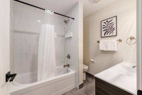 a bathroom with a tub and a sink and a toilet at Pet Friendly & Accessible, 4 Beds in Calgary