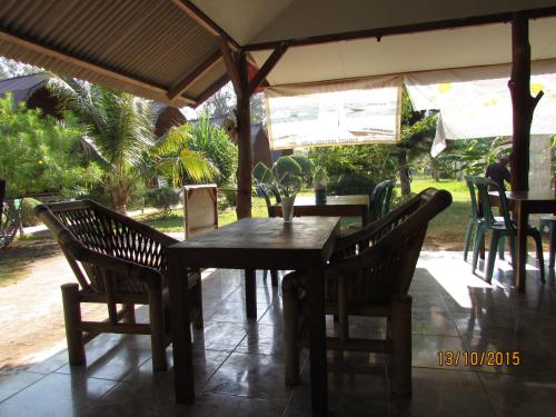 a wooden table and chairs on a patio at II Bungalow in Gili Meno