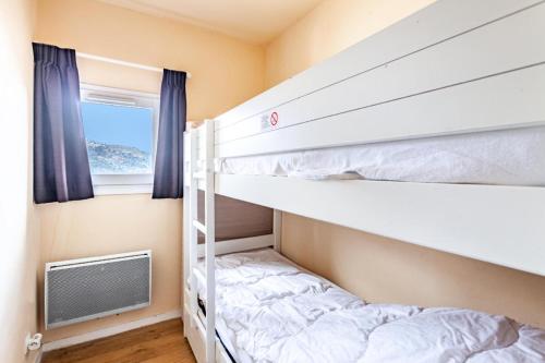 une chambre avec deux lits superposés et une fenêtre dans l'établissement Résidence Le Thabor - maeva Home - Appartement 4 pièces 6 personnes - Sélection MAE-8754, à Le Désert