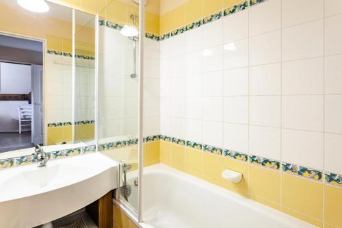 une salle de bain avec une baignoire, un lavabo et un miroir dans l'établissement Résidence Le Thabor - maeva Home - Appartement 4 pièces 6 personnes - Sélection MAE-8754, à Le Désert