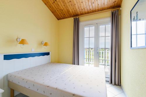 une chambre avec un lit et une grande fenêtre dans l'établissement Résidence Port Bourgenay - maeva Home - Appartement 2 pièces 7 personnes - Sélection MAE-4834, à Talmont-Saint-Hilaire