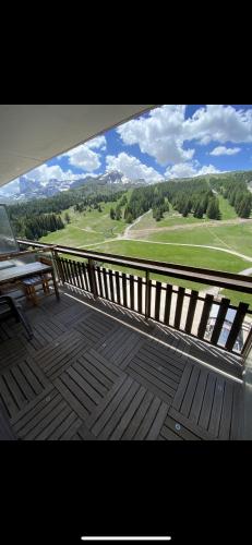 a balcony with a bench and a view of a golf course at Studio aux pieds des pistes et des commerces in Le Dévoluy