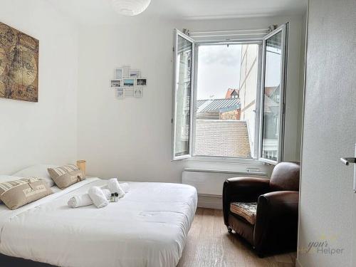 une chambre avec un lit, une chaise et une fenêtre dans l'établissement Terrasse Urbaine YourHostHelper, à Deauville