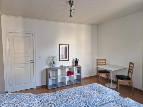 a bedroom with a bed and a table and a desk at Cozy Retreat in the Heart of Ålesund in Ålesund