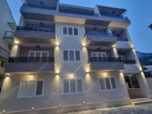 a white building with lights on the side of it at House Villa Roza in Tučepi