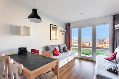 un salon avec une table et un canapé dans l'établissement Résidence Le Thabor - maeva Home - Appartement 2 pièces 5 personnes - Confort MAE-0294, à Le Désert