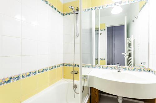 une salle de bain avec une baignoire, un lavabo et un miroir dans l'établissement Résidence Le Thabor - maeva Home - Appartement 2 pièces 5 personnes - Confort MAE-0294, à Le Désert