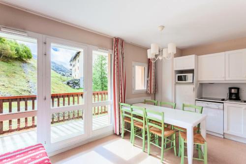 Il dispose d'un balcon et d'une cuisine avec une table et des chaises. dans l'établissement Résidence Le Thabor - maeva Home - Appartement 3 pièces 6 personnes - Confort MAE-8734, à Le Désert