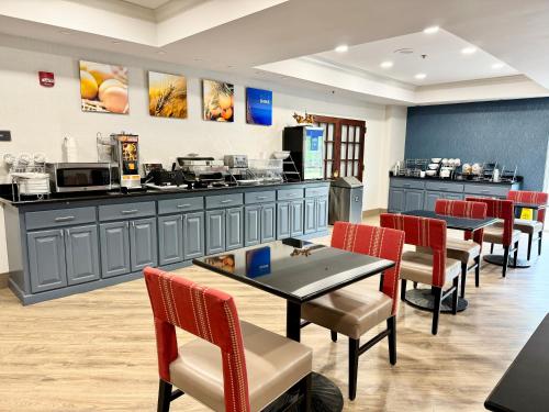 a restaurant with tables and chairs and a counter at Comfort Suites East Brunswick - South River in East Brunswick