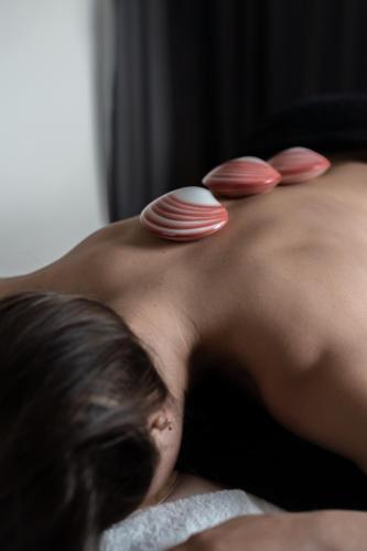 a woman laying on a bed with plates on her back at Noordzee, Hotel & Spa in Cadzand-Bad