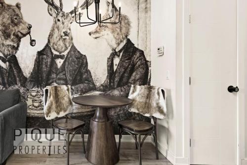 a room with a table and a mural of animals at Mountain Haven Retreat, Pool & Hot Tub, UG Parking, Fitness Centre, WiFi! in Canmore