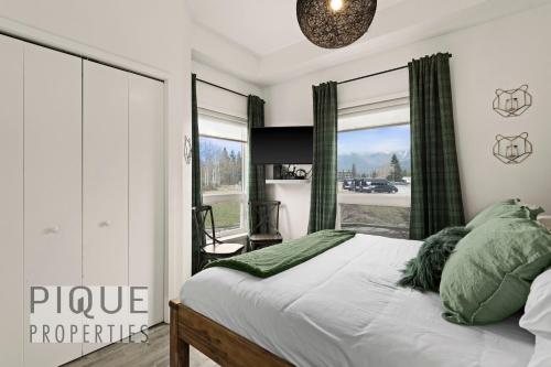 a bedroom with a bed and a large window at Mountain Haven Retreat, Pool & Hot Tub, UG Parking, Fitness Centre, WiFi! in Canmore