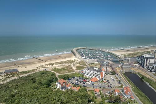 una vista aerea di una spiaggia con ponte di Noordzee, Hotel & Spa a Cadzand-Bad