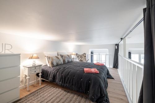 - une chambre avec un lit et une couette noire dans l'établissement La Petite Chaise Bleue, à Nice